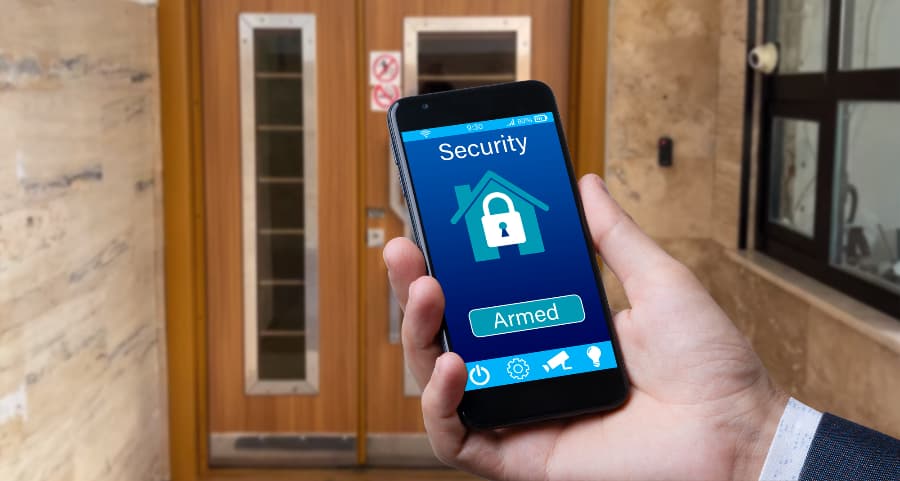 Person using cell phone to arm a home security system